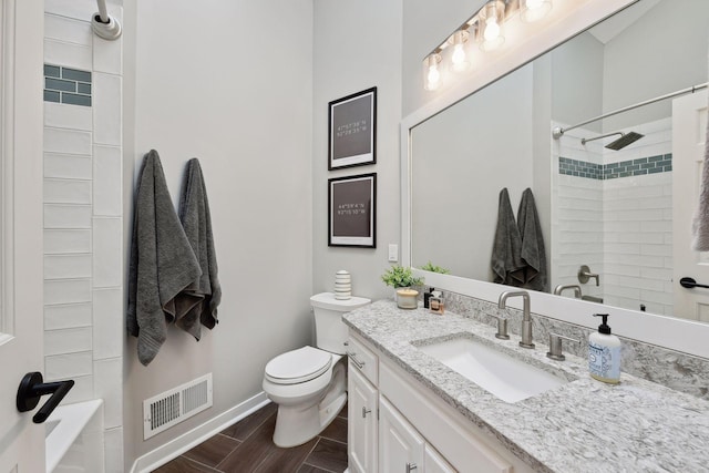 full bathroom with vanity, tiled shower / bath combo, and toilet