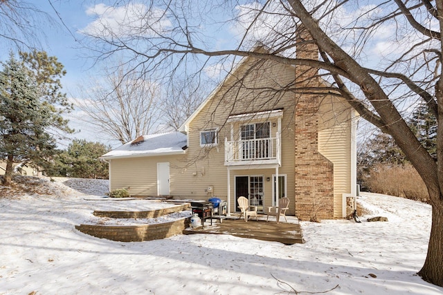 snow covered property featuring a balcony