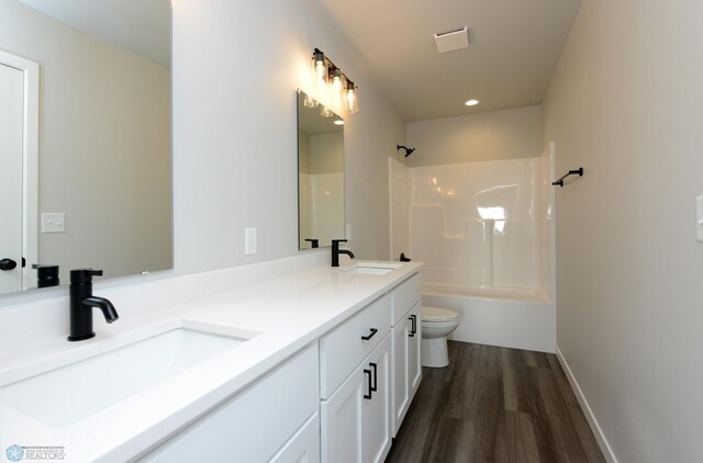 full bathroom featuring shower / washtub combination, hardwood / wood-style floors, vanity, and toilet