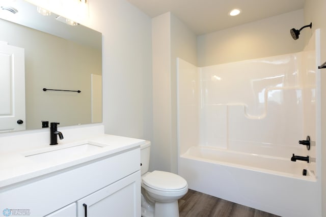 full bathroom with vanity, hardwood / wood-style flooring, shower / bathtub combination, and toilet