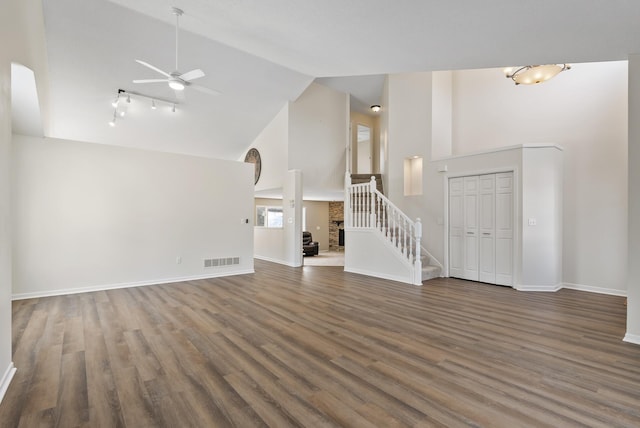 unfurnished living room with dark wood-type flooring, high vaulted ceiling, and ceiling fan