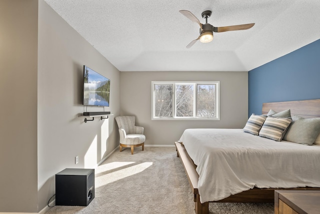 carpeted bedroom with ceiling fan and a textured ceiling