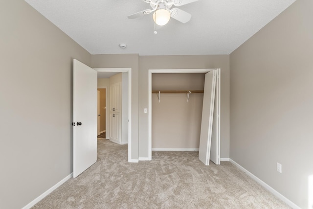 unfurnished bedroom featuring light colored carpet, a closet, and ceiling fan