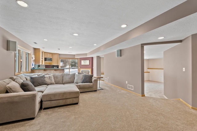 living room featuring light carpet and a textured ceiling