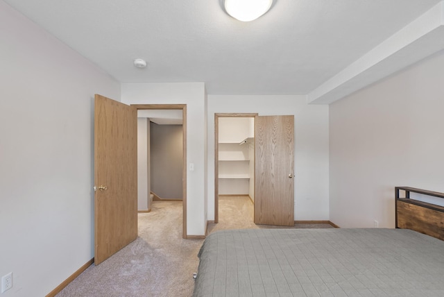 bedroom with light carpet, a spacious closet, and a closet