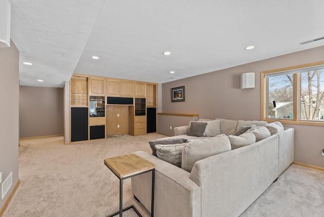 living room featuring light colored carpet and a textured ceiling