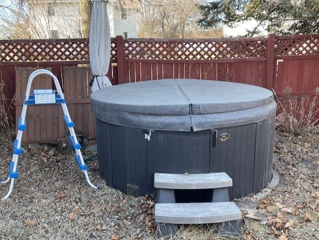 exterior space with fence and a hot tub