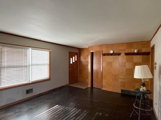 unfurnished living room featuring dark wood-style floors and baseboards