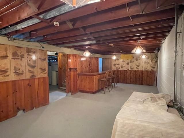 unfinished basement with wooden walls and a dry bar