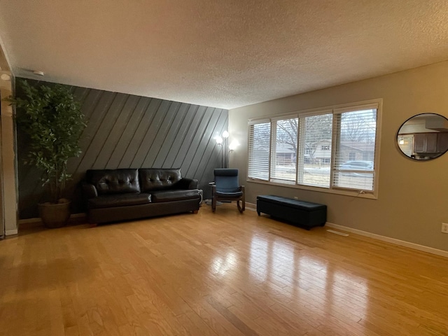 unfurnished living room with a textured ceiling and light wood-type flooring