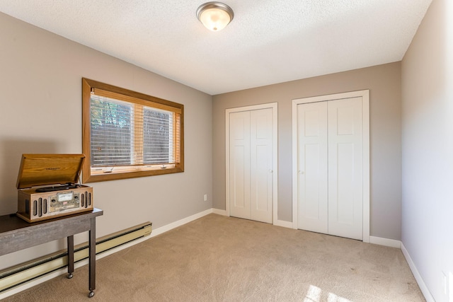 carpeted office with a baseboard radiator and a textured ceiling