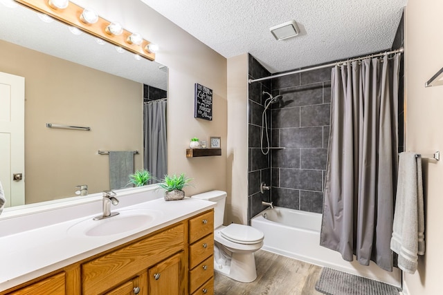 full bathroom with shower / tub combo with curtain, toilet, a textured ceiling, vanity, and hardwood / wood-style floors