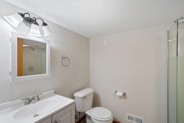 bathroom with vanity, toilet, and a shower with shower door