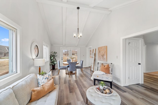 dining room featuring an inviting chandelier, beam ceiling, high vaulted ceiling, and hardwood / wood-style flooring