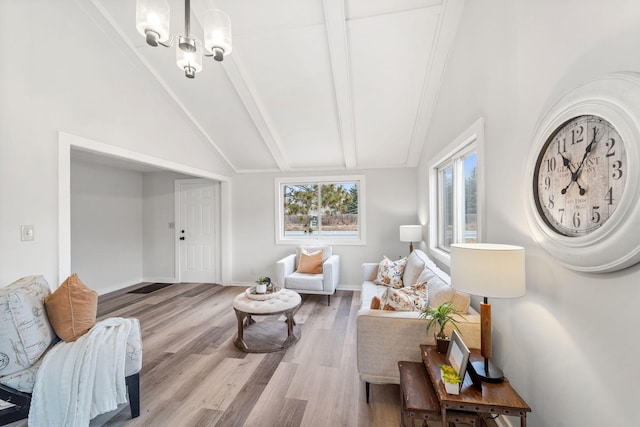 living room with an inviting chandelier, lofted ceiling with beams, and light hardwood / wood-style floors