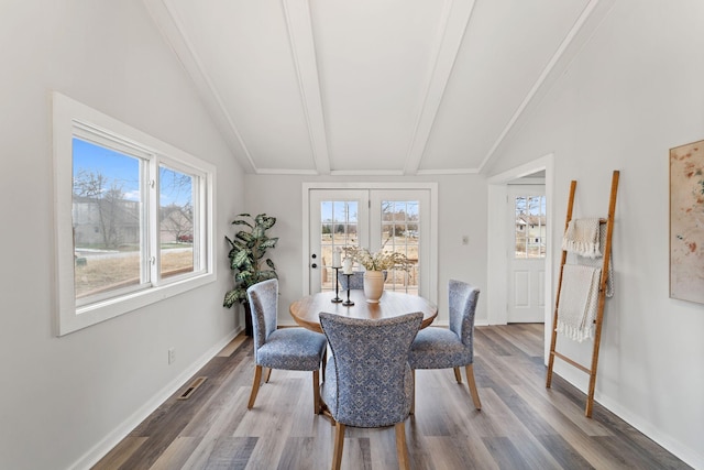 dining space featuring hardwood / wood-style flooring and vaulted ceiling with beams