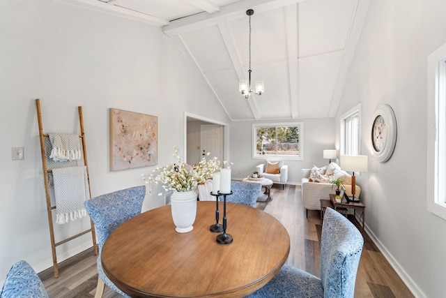 dining room with hardwood / wood-style flooring, a notable chandelier, high vaulted ceiling, and beamed ceiling