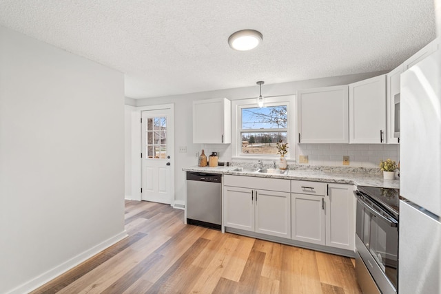 kitchen with sink, white cabinetry, hanging light fixtures, range with electric stovetop, and stainless steel dishwasher