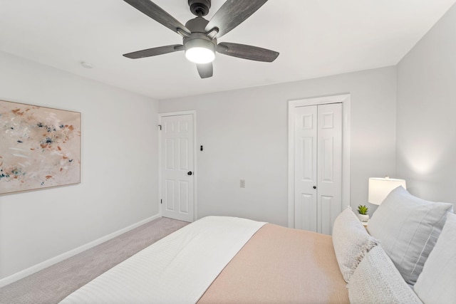 bedroom featuring light colored carpet, a closet, and ceiling fan