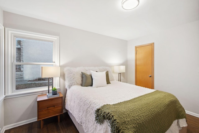 bedroom with multiple windows and dark hardwood / wood-style flooring