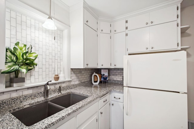 kitchen with pendant lighting, sink, white cabinets, backsplash, and white fridge