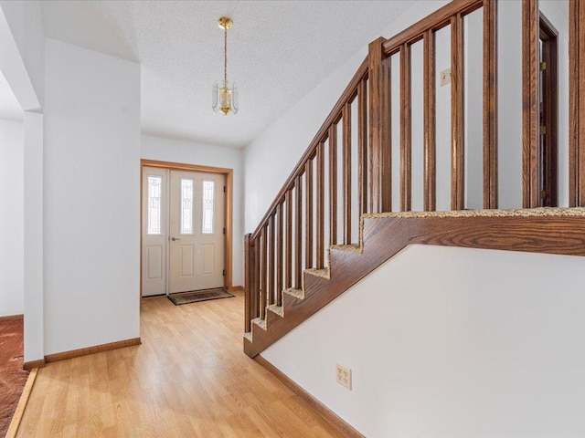 entryway featuring a textured ceiling and light wood-type flooring