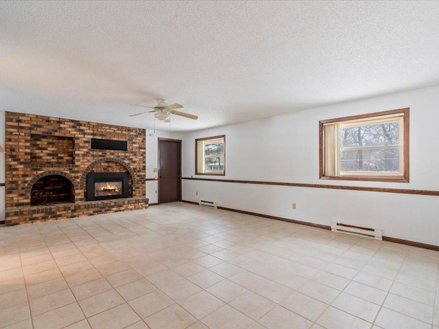 unfurnished living room with a baseboard radiator, a brick fireplace, a wealth of natural light, and a textured ceiling