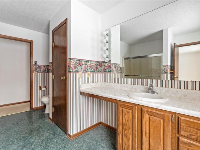 bathroom featuring vanity, toilet, an enclosed shower, and a textured ceiling