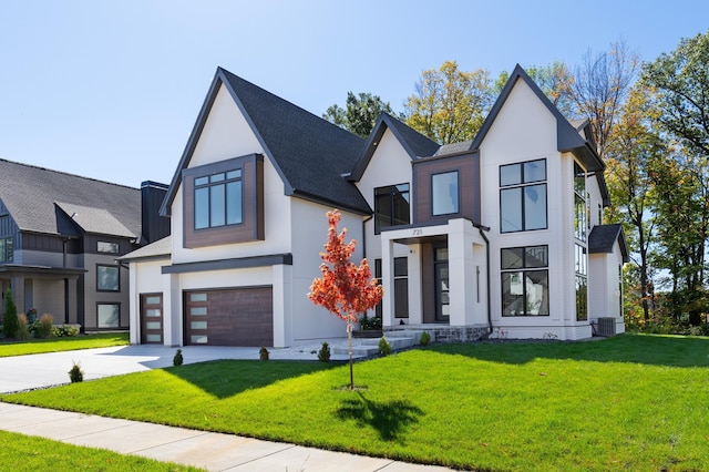 view of front of house featuring central AC, a garage, and a front lawn