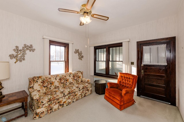 carpeted living room with ceiling fan