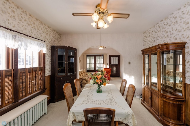 carpeted dining room with radiator and ceiling fan