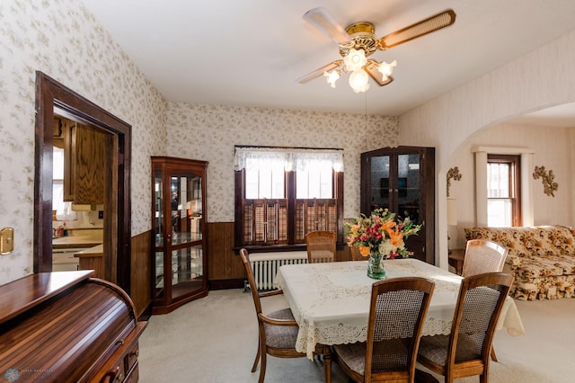 carpeted dining area with french doors, ceiling fan, plenty of natural light, and radiator