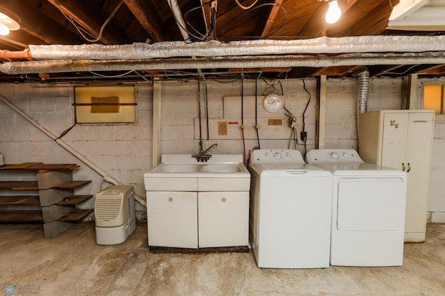 clothes washing area with washing machine and clothes dryer and sink