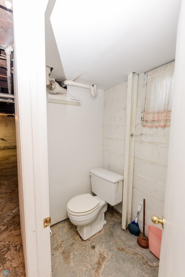 bathroom with concrete flooring and toilet