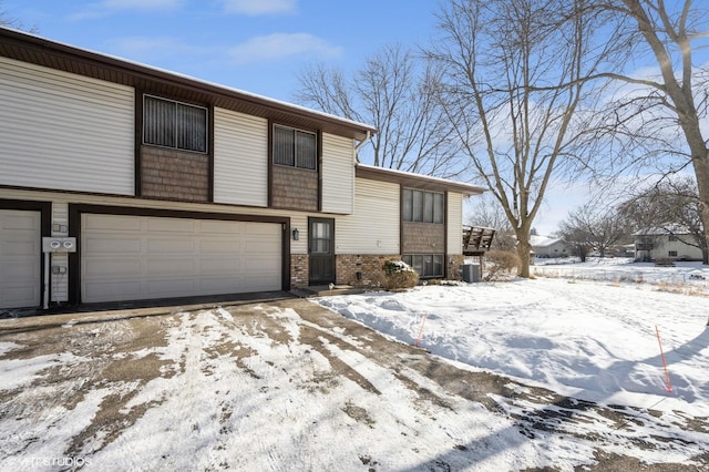 view of front of home featuring a garage and central AC