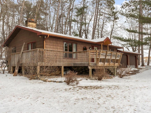 snow covered property with a garage