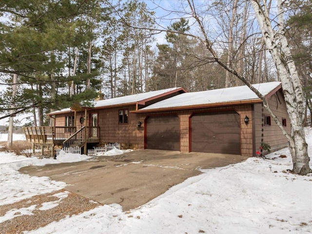 view of snow covered exterior featuring a garage and a wooden deck