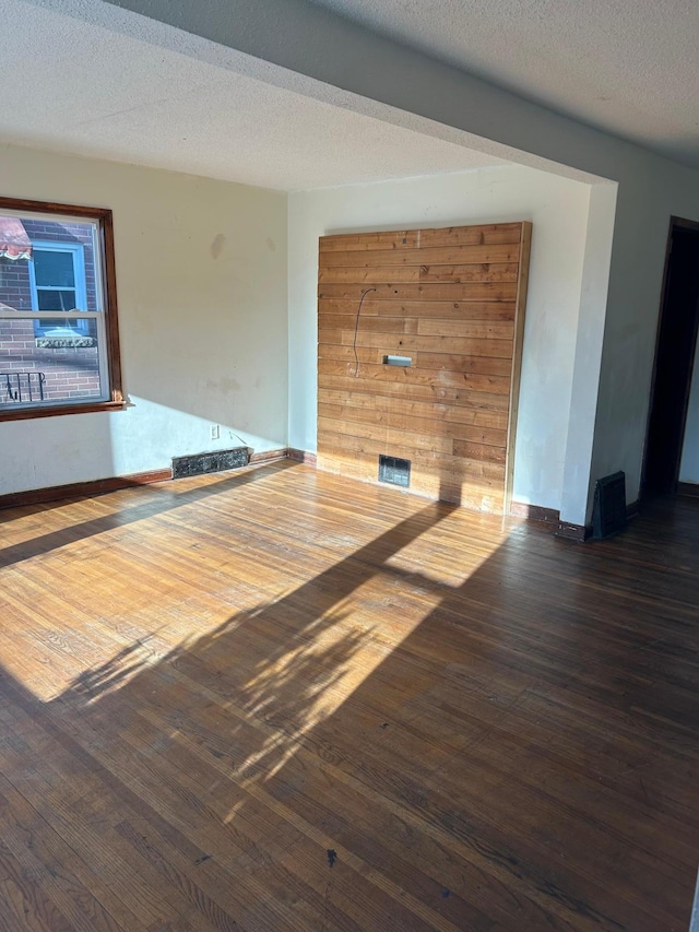 spare room with dark hardwood / wood-style floors and a textured ceiling