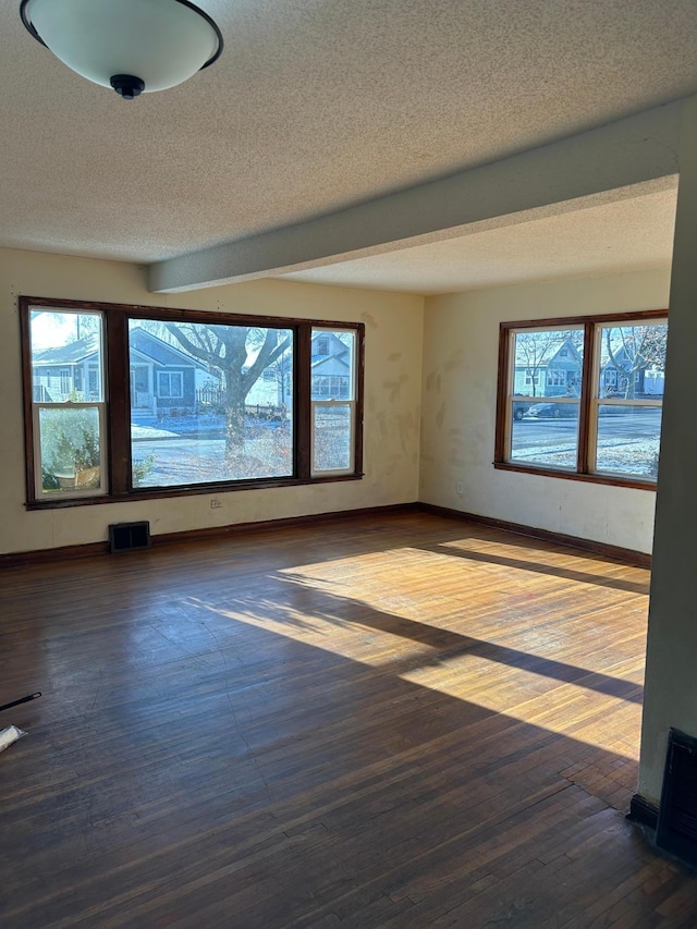 empty room with hardwood / wood-style floors and a textured ceiling