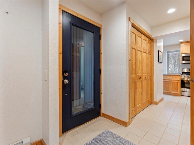 corridor featuring baseboard heating and light tile patterned floors