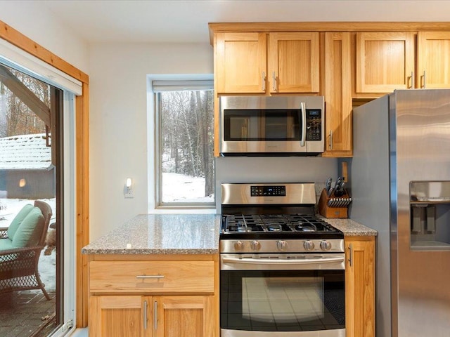 kitchen with appliances with stainless steel finishes and light stone countertops