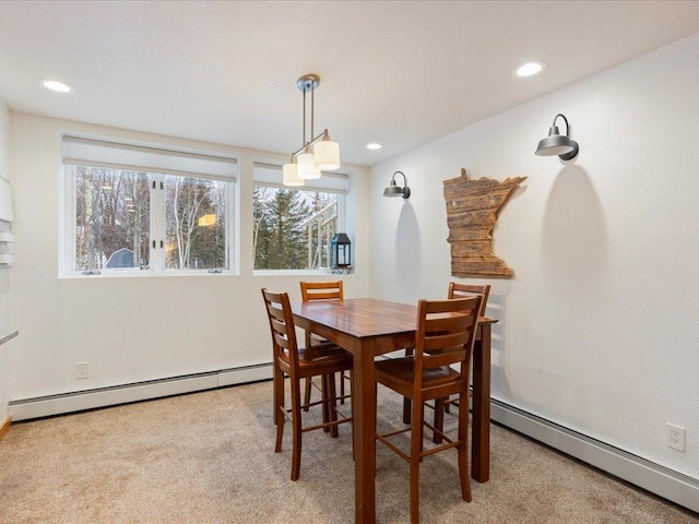 dining room with light carpet and baseboard heating