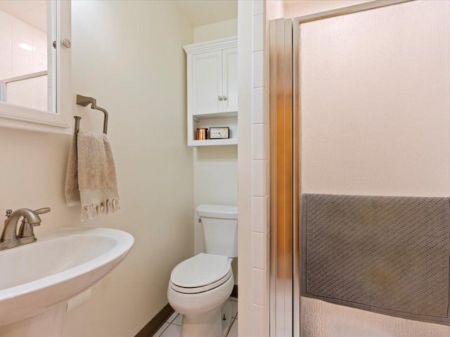 bathroom featuring sink, an enclosed shower, and toilet