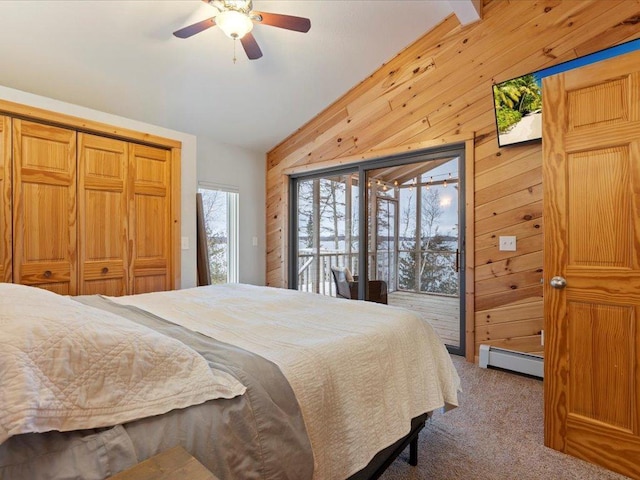 bedroom with lofted ceiling, baseboard heating, wooden walls, carpet flooring, and access to outside