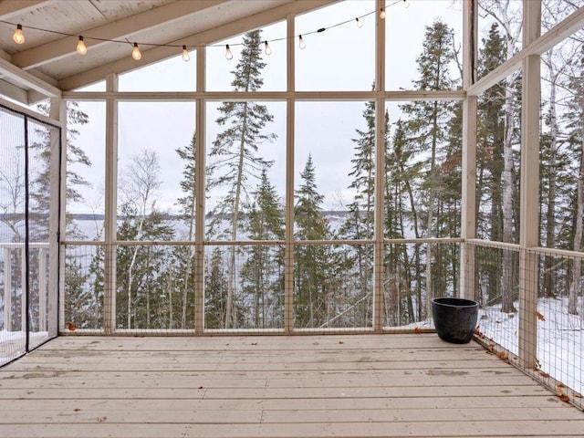 unfurnished sunroom with track lighting and lofted ceiling