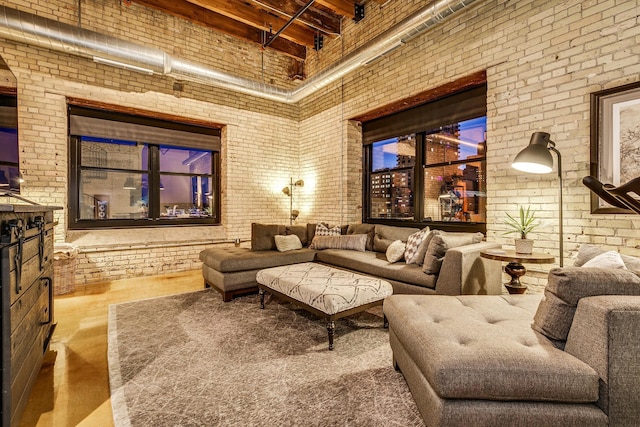 cinema room featuring hardwood / wood-style floors, brick wall, and a high ceiling