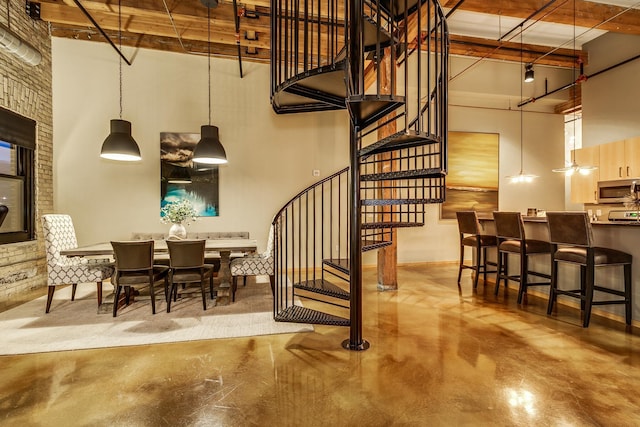 staircase featuring a towering ceiling and concrete flooring