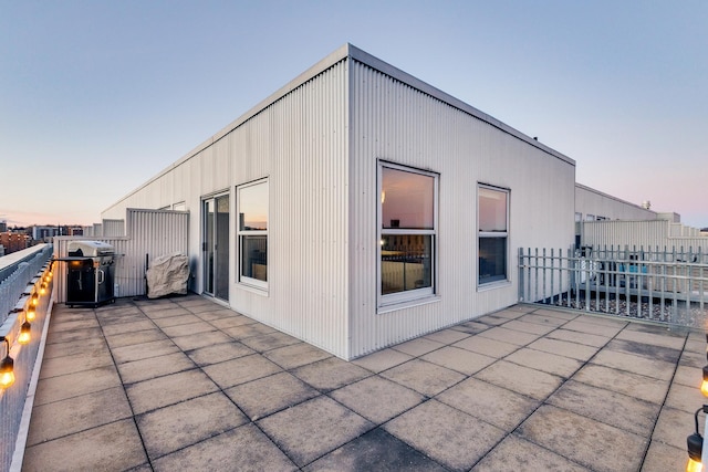 back house at dusk featuring a patio