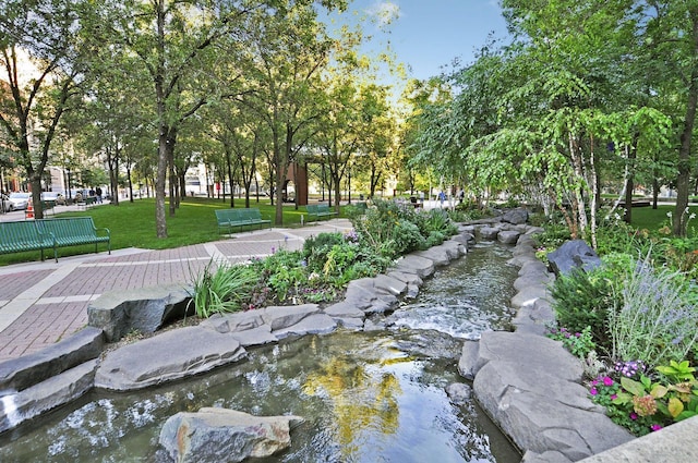 surrounding community with a yard and a garden pond