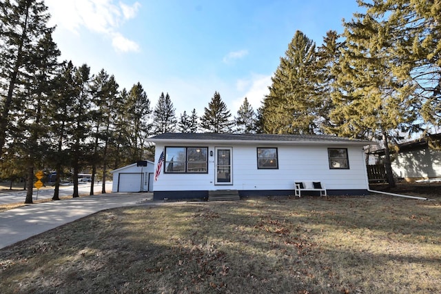 ranch-style home featuring an outbuilding, a garage, and a front lawn